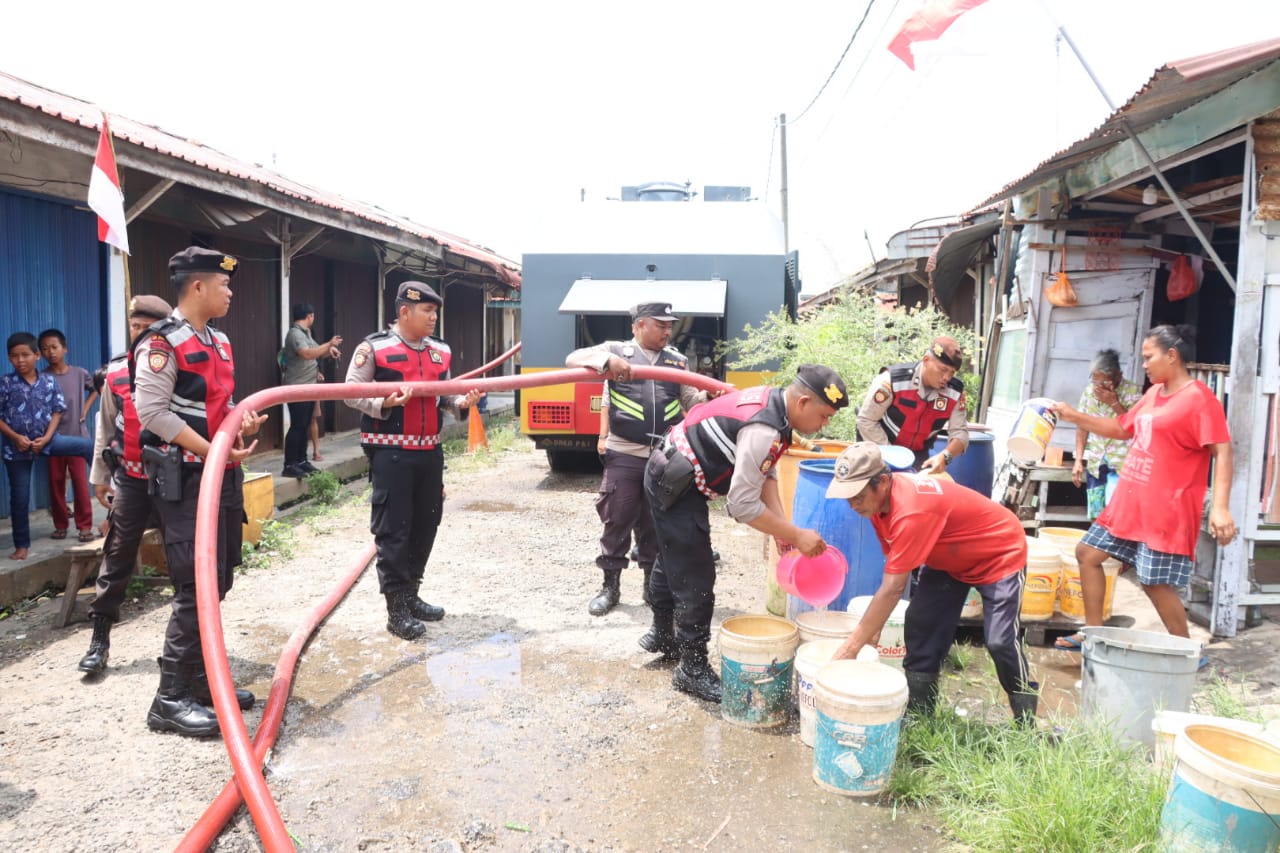 Anggota Polres Karimun saat membagikan air bersih ke warga Sei Lakam, kemarin sore. (ft yudi)