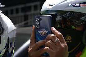 Polantas sedang menggunakan HP sebagai cara tilang elektronik. (ft otomotifnet)