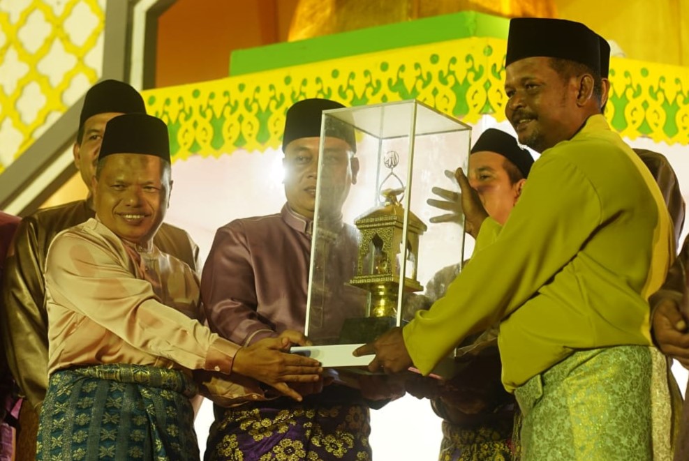 Bupati M Nizar saat menyerahkan piala bergilir MTQH X kepada Kecamatan Singkep Barat, tadi malam. (ft andi)