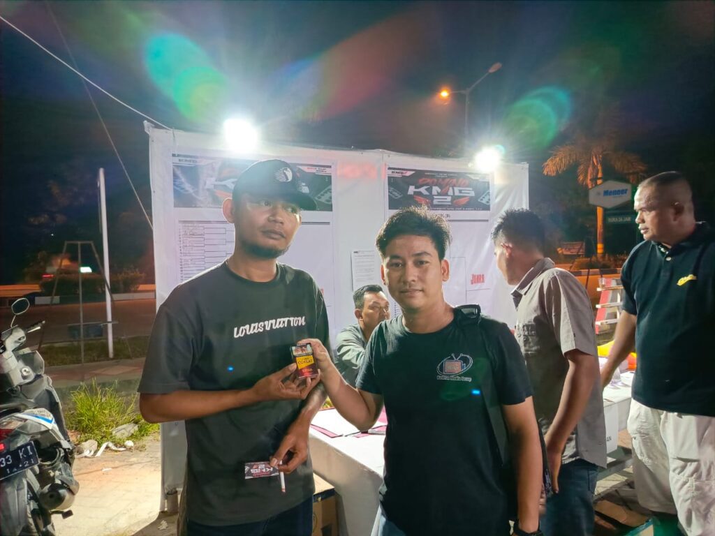 Seorang pendaftar mendapatkan sebungkus rokok dari panitia usai mendaftarkan diri di Turnamen Domino KMG Cup II, malam ini. (ft msaimi)