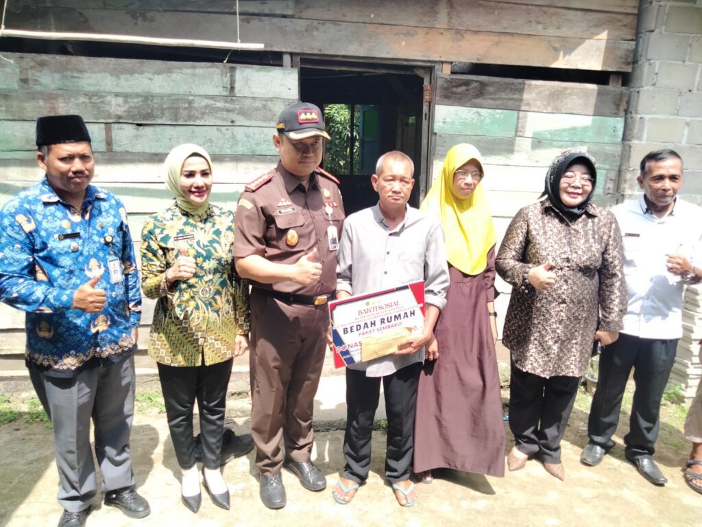 Kejari Karimun berfoto bersama usai penyerahan bantuan bedah rumah kepada seorang warga Pelambung Desa Pongkar, siang tadi. (ft msaimi)