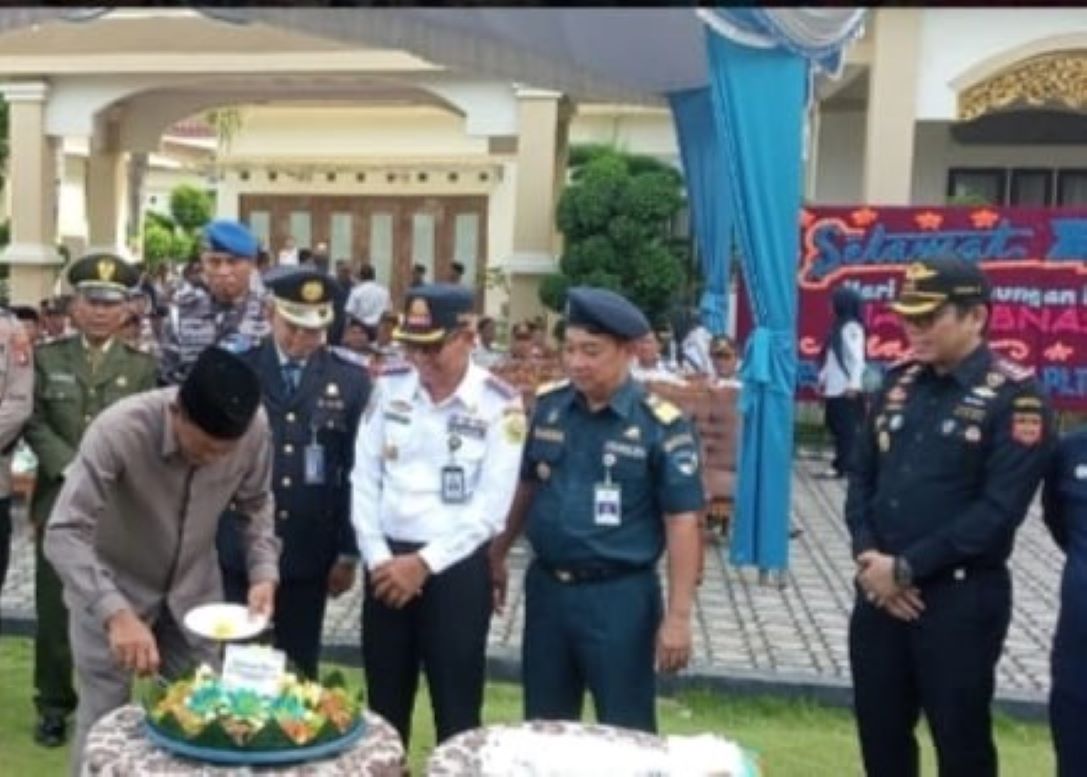 Plt Sekdakab Karimun Djunaidy saat memotong tumpeng usai upacara Harhubnas 2024 di halaman kediaman dinas bupati, pagi tadi. (ft msaimi)