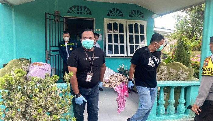 Petugas polisi saat mengevakuasi nenek yang meninggal di dalam rumahnya, siang tadi. (ft novel)