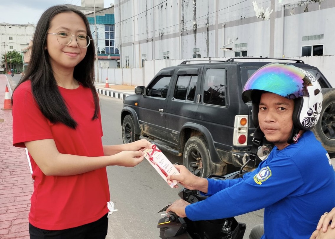 Seorang siswa SMANDA Singkep saat membagikan souvenir kepada seorang warga dalam rangka hari HIV/Aids sedunia, pagi tadi. (ft imam)