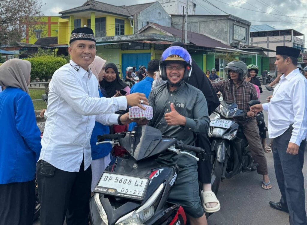 Kasatintelkam Polres Lingga dan mahasiswa saat membagikan takjil ke masyarakat, kemarin sore. (ft gafar)