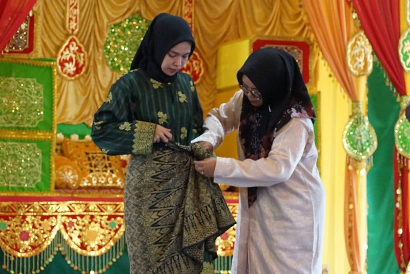 Disbud Lingga saat mencontohkan berpakaian Melayu. (ft diskominfolingga)