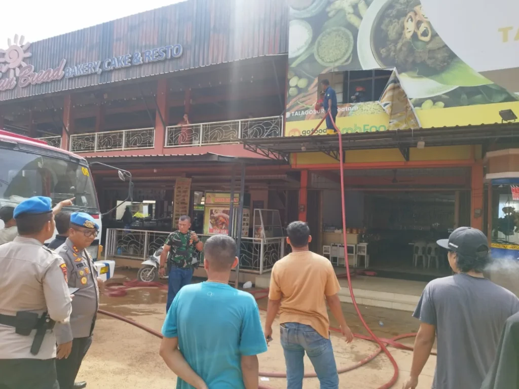 Petugas pemadam kebakaran saat memadamkan api di Rumah Makan Talago Surya, kemarin. (ft ami kutipan)