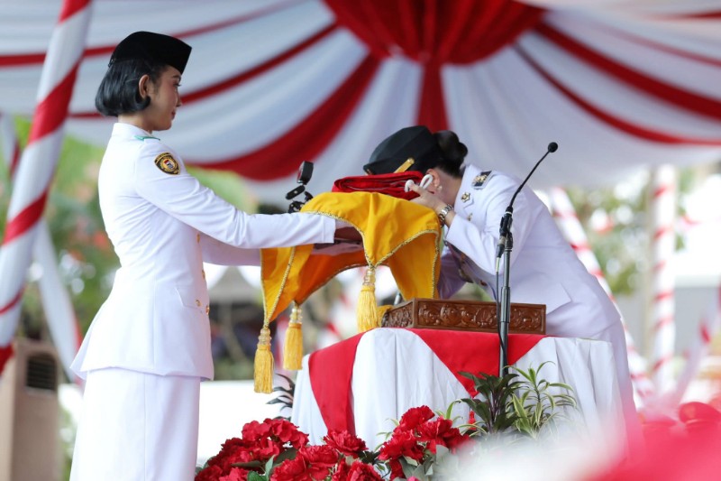 Li Claudia mencium bendera saat penurunan bendera HUT RI, sore tadi. (ft mcbatam)