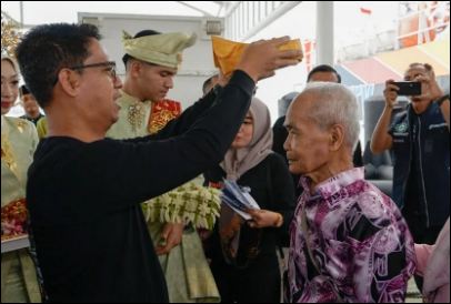 Bupati memakaikan tanjak untuk Wisman Perdana ke Karimun. (ft msaimi)