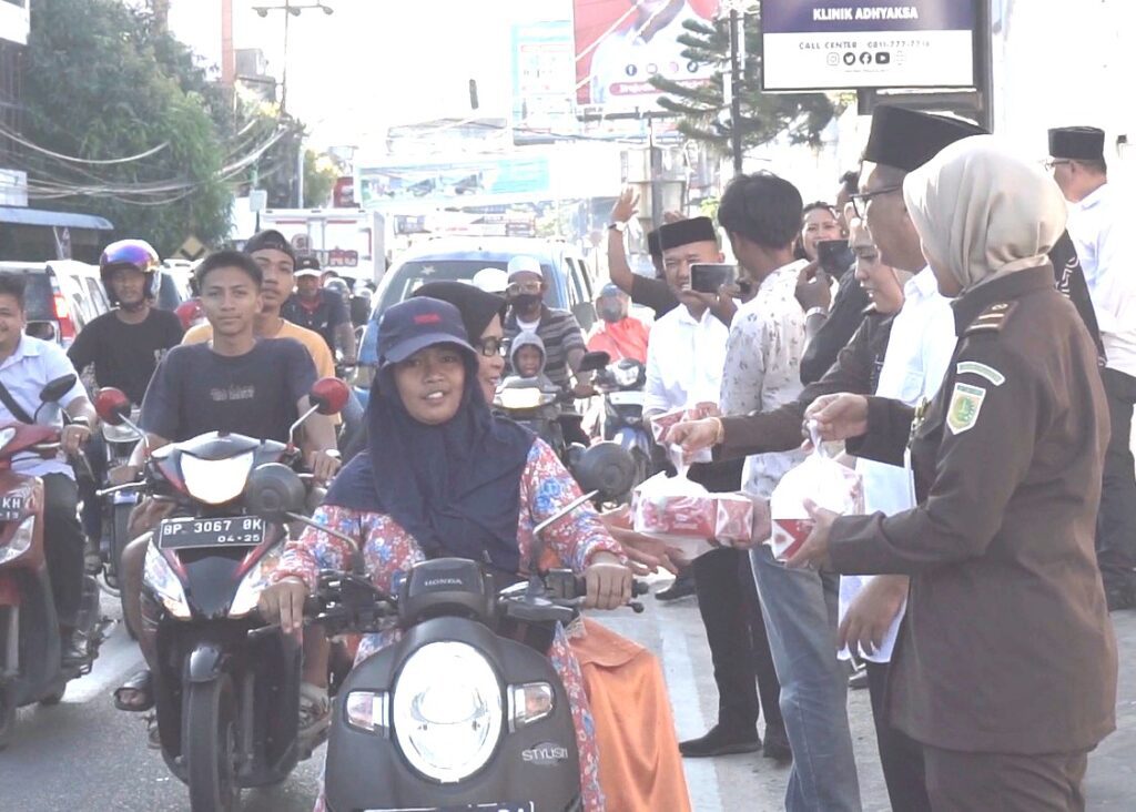 Kepala Kejari Tanjungbalai Karimun bersama jajarannya berbagi paket takjil kepada warga yang melintas di depan kantornya. “Ini upaya kita lebih mendekatkan diri kepada masyarakat. Kehadiran kita untuk masyarakat agar lebih dapat dirasakan,” ujar Kajari Firdaus melalui Kasi Intelijen Kejari Karimun. Sebanyak 100 paket takjil dibagikan sekira pukul 17.00 WIB bertempat di depan Kantor Kejaksaan Negeri Karimun. Selain pembagian paket takjil, jajaran di Kejari Tanjungbalai Karimun juga melakukan pembagian sembako dengan konsep membuat sebuah tempat khusus di tepi jalan di depan kantor Kejaksaan Negeri Karimun. Tempat ini digunakan untuk menggantung barang-barang berupa Sembako atau lainnya yang nantinya di tempat itu masyarakat bisa mengambil apa yang ada di situ secukupnya.
