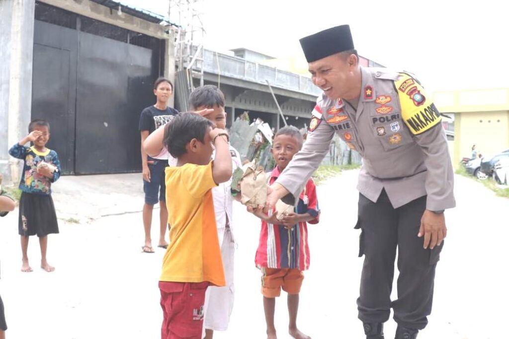 Wakapolres Karimun Kompol Herie Pramono saat membagikan nasi bungkus ke anak-anak di Kolong, siang tadi. 9ft yudi)