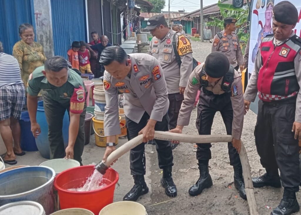 Kapolres Karimun beserta jajarannya saat membagikan air bersih ke warga di Pongkar, siang ini. (ft msaimi)