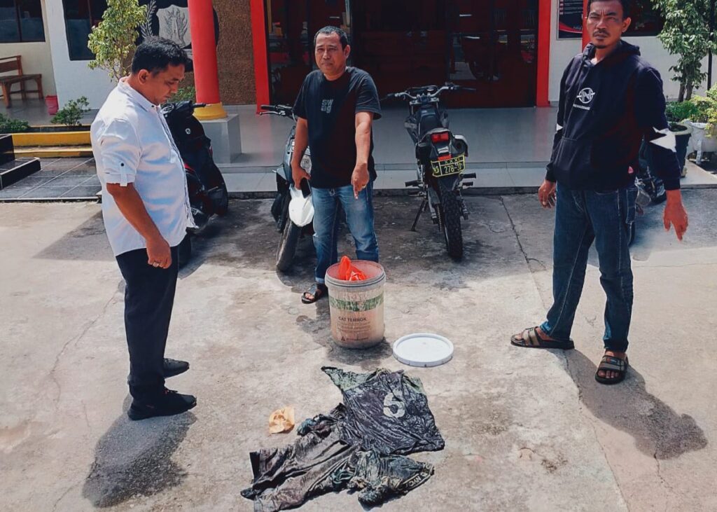 Petugas Polsek Moro saat menunjukkan barang bukti dan menyerahkannya kepada pihak keluarga korban yang telenggelam di Perairan Moro, pagi tadi. (dt polsekmoro)