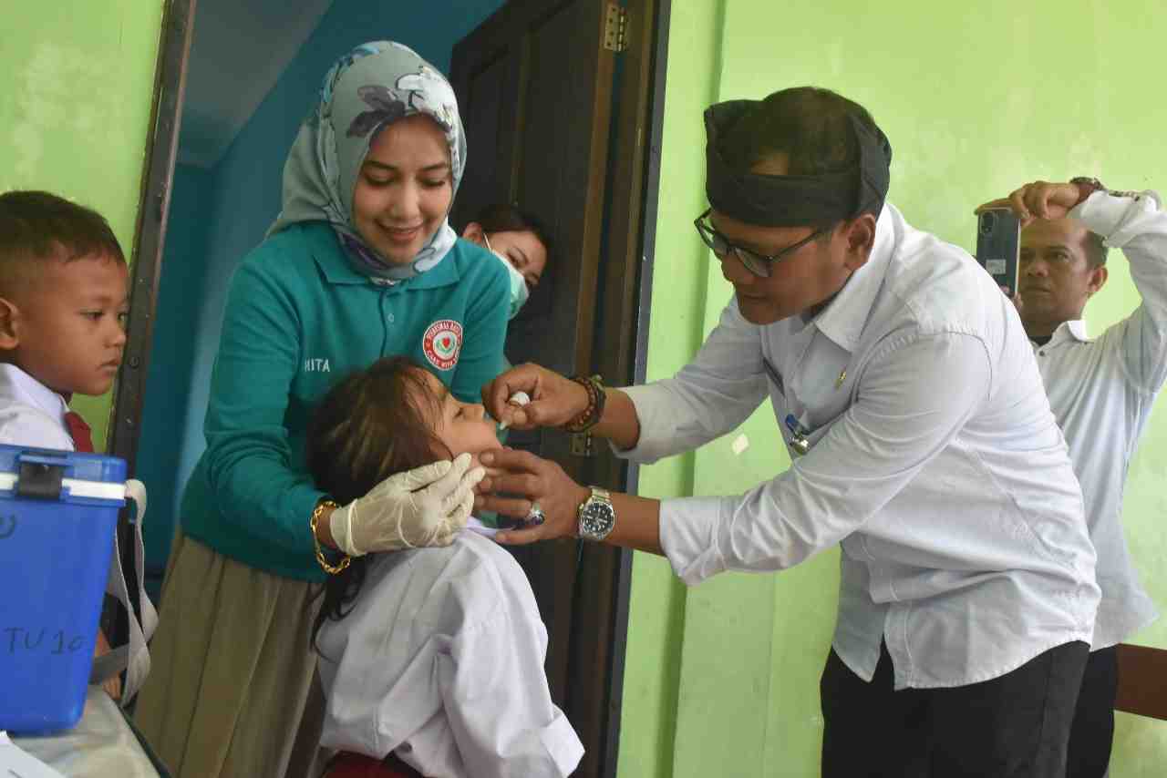 Kadiskominfo Tanjungpinang saat memberikan imunisasi polio kepada salah satu siswa SDN 017 Tanjungpinang, pagi tadi. (kominfotjpinang)