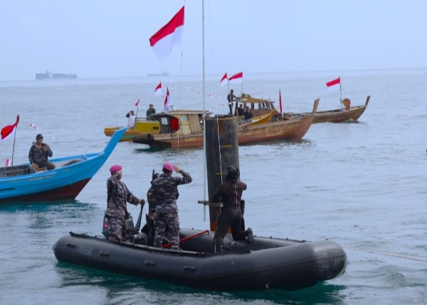 Prajurit Yonmarhanlan IV mengibarkan Bendera Merah Putih, tepatnya di Karang Singa perairan perbatasan Indonesia, Malaysia dan Singapura, Kabupaten Bintan. (ft lantamaliv)