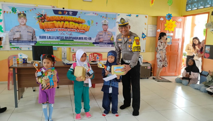 Kasat Lantas Polres Karimun AKP Bakri menyerahkan hadiah kepada pemenang lomba mewarnai dalam rangka memperingati Hari Lalu Lintas Bhayangkara ke-69. (ft msaimi)