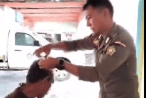 Seorang anggota Satpol PP sedang mencukur ODGJ di depan kantor Satpol PP Karimun, beberapa waktu lalu. (ft dok lendoot)