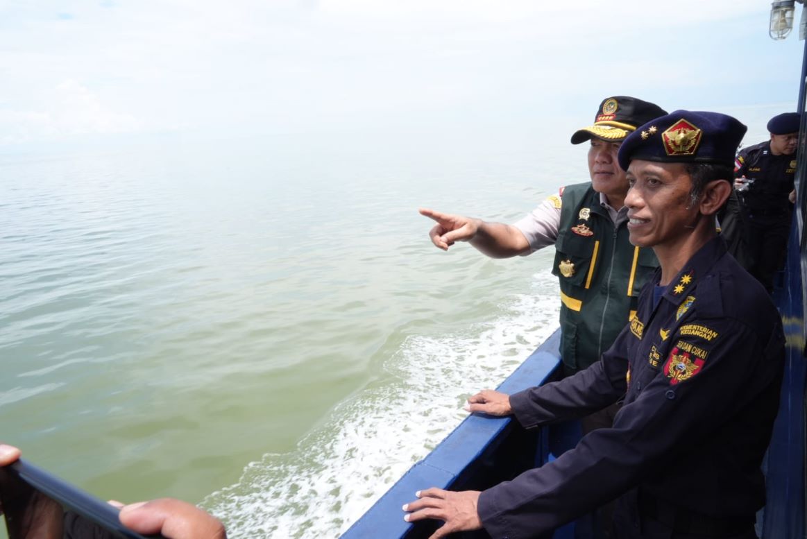 Kepala Barantin,Sahat M Panggabean (menunjuk ke arah laut) saat berpatroli bersama petugas BC di perairan Indonesia, kemarin. (ft barantin)