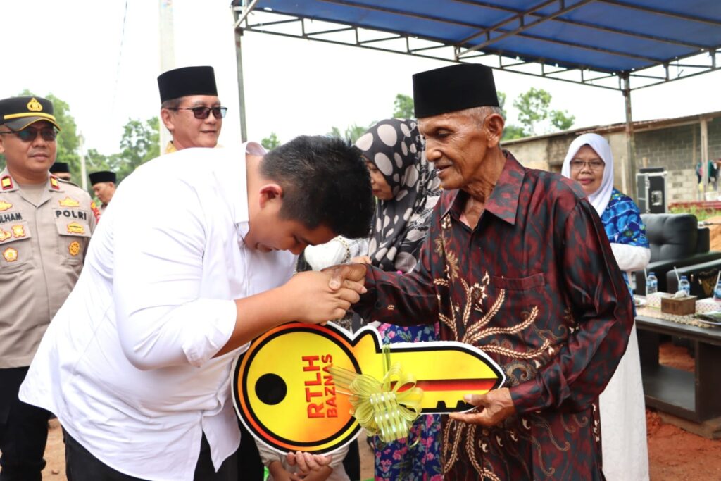 Bupati Bintan Roby Kurniawan saat menyerahkan kunci saat acara penyerahan program RLTH bantuna BAZNAS Bintan, kemarin. (ft mcbintan)
