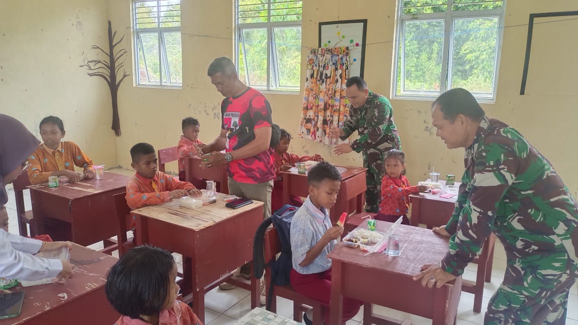 Pemuda Pancasila dan TNI AD saat membantu program makan siang gratis bagi siswa SD 016 Lingga Utara, kemarin. (ft wandy)