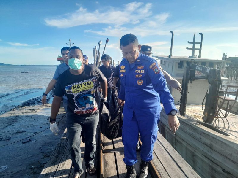 Petugas polisi sedang mengevakuasi mayat pria di Kamkong Meral, sore tadi. (ft ricky)