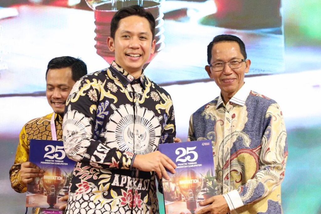 Wali Kota Batam, Amsakar Achmad, menerima buku 25 Praktik Terbaik Pemerintah Kabupaten saat menghadiri Rakernas APKASI XVII di Aston Hotel Batam, Minggu (18/1/2026) malam. (ft mcbatam)