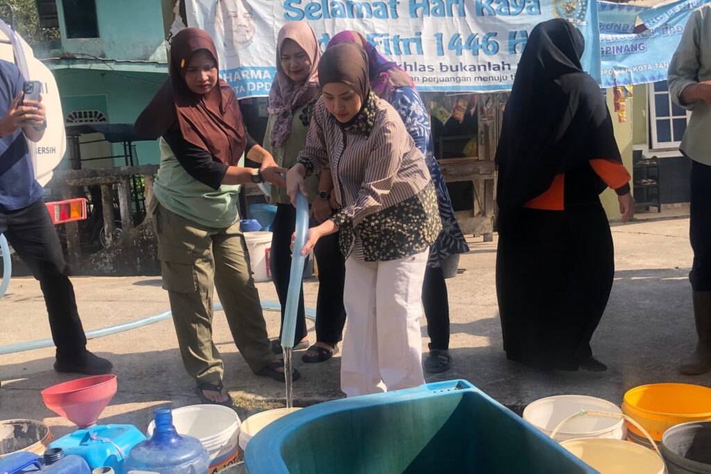 Hafizha Rahmadhani saat menyuplay air bersih bagi warga Bintim, kemarin. (ft mcbintan)