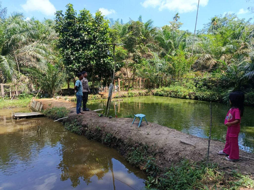 Bhabinkamtibmas Polsek Kelayang Brigadir Cahyadi melaksanakan kegiatan sambang ke peternakan ikan milik warga Desa Kota Medan, kemarin. (ft muhamad)
