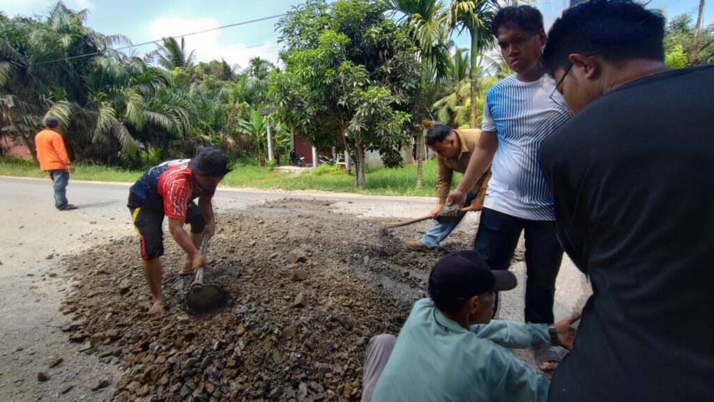 Pemdes Sungai Gantang saat menggandeng swasta untuk menambal jalan Provinsi untuk keselamatan warga pengendara, kemarin,. (ft muhamad(